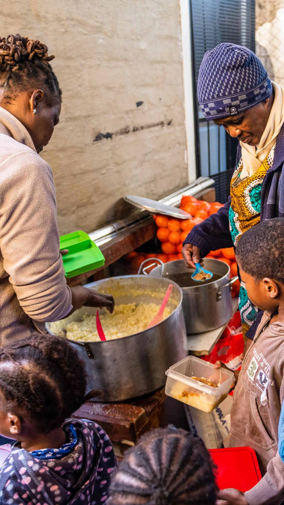 People coming together at a community kitchen to serve nourishing meals to children